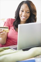 African American woman shopping online with credit card