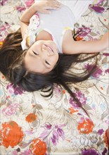 Smiling Korean girl laying on bed