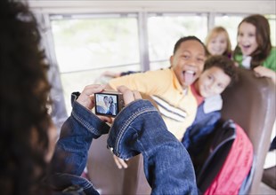 Girl taking photographs on school bus