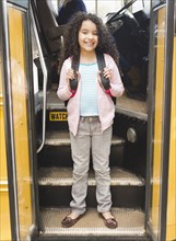 Hispanic girl getting onto school bus