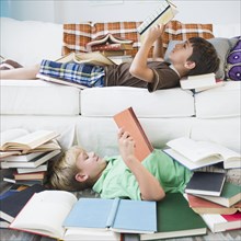 Boys reading books in living room