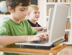 Boys using laptops in classroom