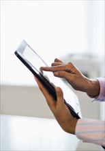 Hispanic businesswoman using digital tablet in office