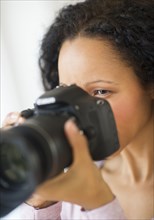 Hispanic woman taking photographs with camera