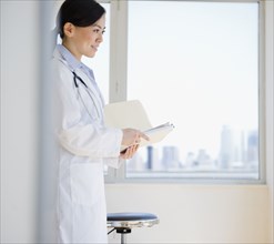 Smiling Japanese doctor holding medical record