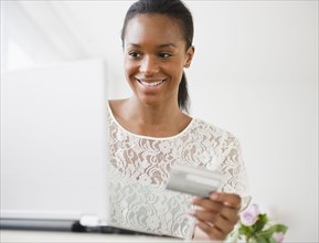 Black woman shopping online with credit card