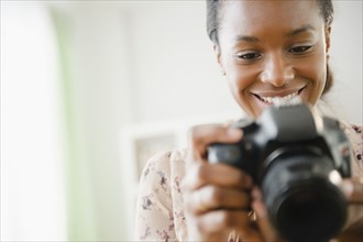 Black woman using digital SLR camera
