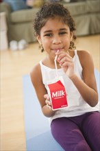 Mixed race girl drinking milk