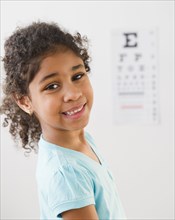 Mixed race girl having an eye exam