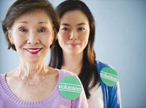 Japanese mother and daughter wearing volunteer stickers