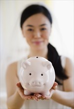 Japanese bride holding piggy bank