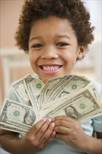 Black boy holding one dollar bills