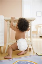 Black baby girl pulling up on table