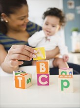 Mixed race mother and baby playing with alphabet blocks