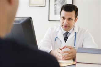 Mixed race doctor talking to patient