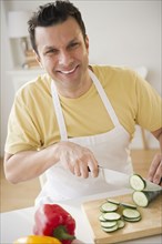 Mixed race man slicing vegetables
