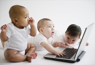 Babies playing with laptop