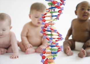 Babies sitting with DNA helix