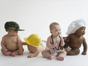 Babies in occupational hats sitting on floor together