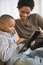 Black mother and son using digital tablet