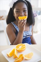 Black girl eating oranges