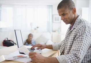 Mixed race man paying bills online