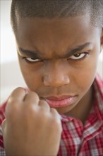 African American boy frowning and making a fist