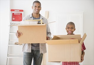 Father and son holding moving boxes