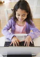 Mixed race girl using laptop