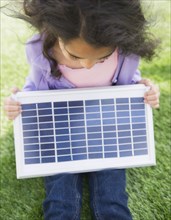 Mixed race girl holding solar panel