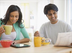 Mixed race couple eating breakfast