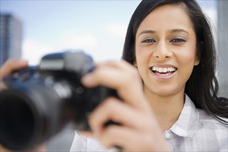 Mixed race woman taking photographs