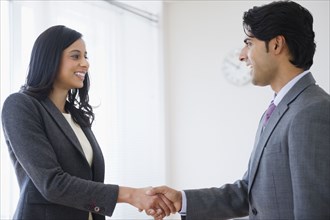 Mixed race business people shaking hands