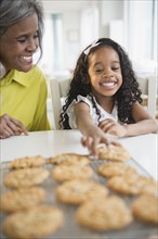 African American grandmother and granddaughter baking cookies