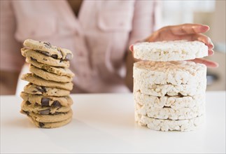 Cape Verdean woman stacking cookies and rice cakes