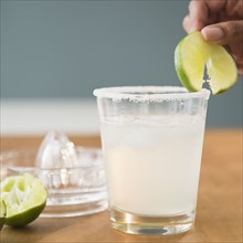 Cape Verdean woman putting lime on cocktail