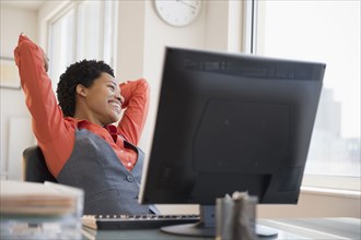 African American businesswoman relaxing at desk