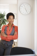 Impatient African American businesswoman leaning against wall