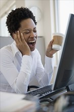 African American woman yawning at desk