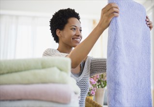 African American woman folding towels