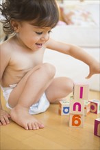 Mixed race girl playing with blocks