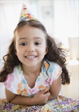 Smiling mixed race girl in party hat