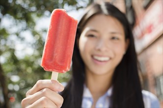 Asian woman eating popsicle