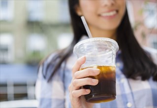 Asian woman drinking iced coffee