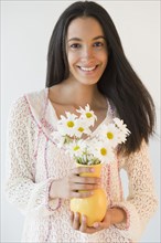 Smiling Hispanic teenager holding flowers
