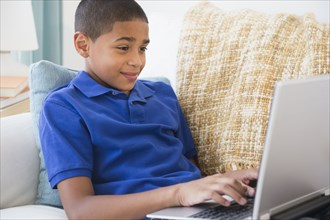 Hispanic boy typing on laptop