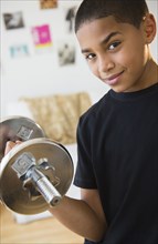 Hispanic boy lifting weights