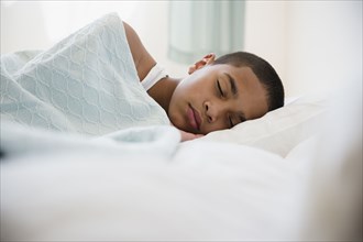 Hispanic boy laying in bed