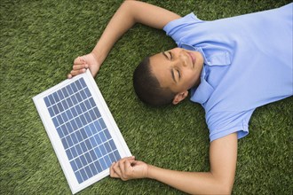 Hispanic boy holding solar panel