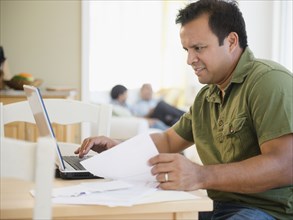 Hispanic man using laptop